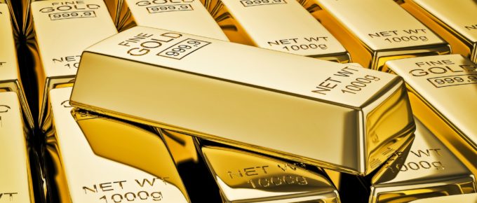 Gold bar on stacks of gold bullions close up